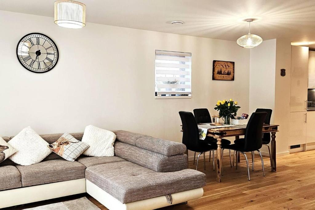 sala de estar con sofá y mesa con sillas en Luxury 3-Bed House in the Scottish Highlands en Inverness