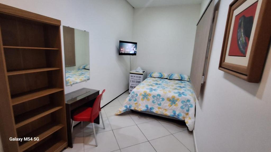 Habitación pequeña con cama, escritorio y escritorio. en SUITE STAR, en Pau dos Ferros
