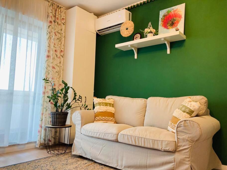 - un salon avec un canapé et un mur vert dans l'établissement The 2nd Place 2be, à Bucarest