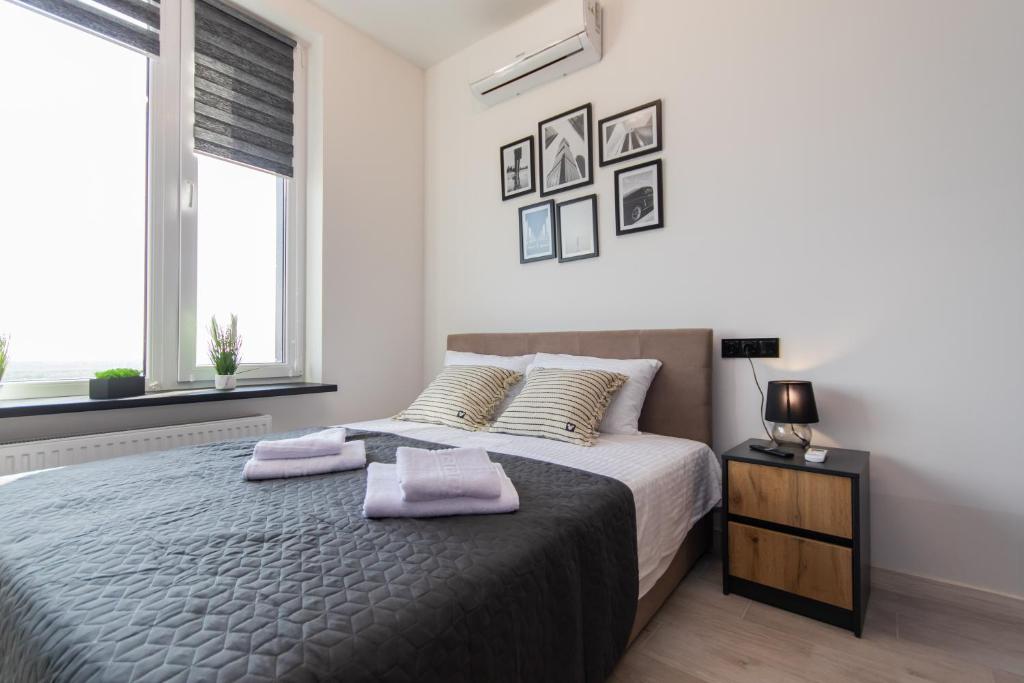 1 dormitorio con 1 cama con 2 toallas en MYFREEDOM Видові Апартаменти ВДНГ, en Kiev