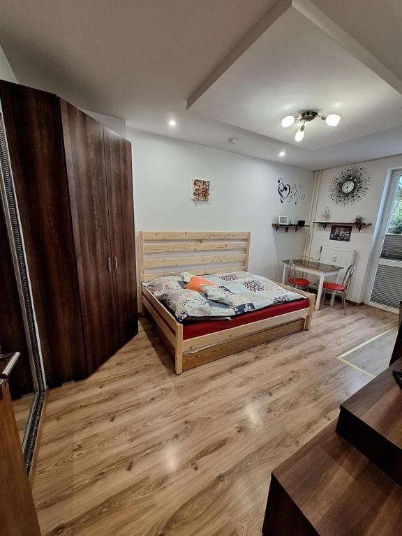 ein Schlafzimmer mit einem Bett und einem Tisch darin in der Unterkunft Diana Apartments 2 in Bardejov