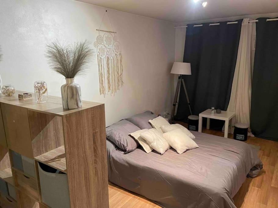 Un dormitorio con una cama con almohadas. en Studio Lac d'Enghien en Enghien-les-Bains