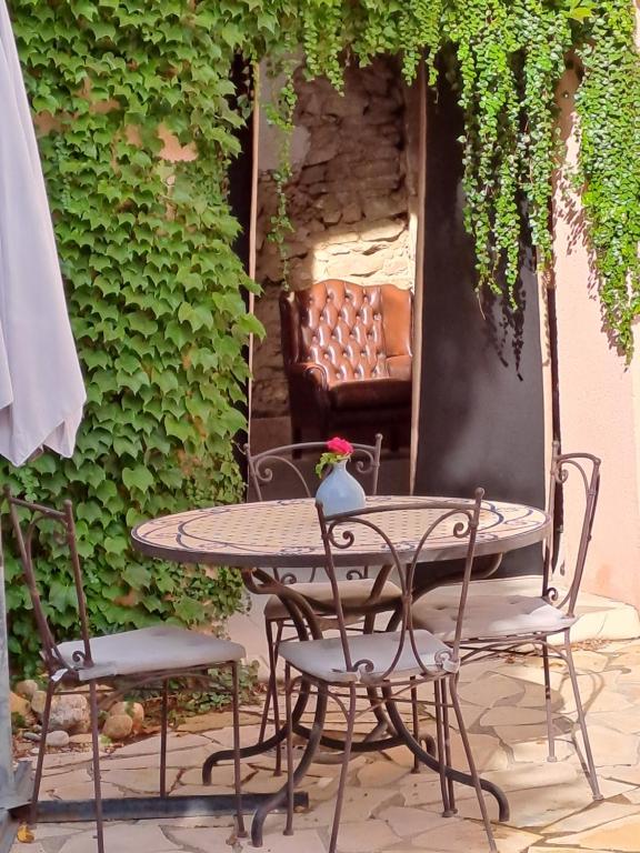 a table and chairs on a patio with a couch at La maisonnette avec SPA, PISCINE et CLIMATISATION in Sainte-Vallière