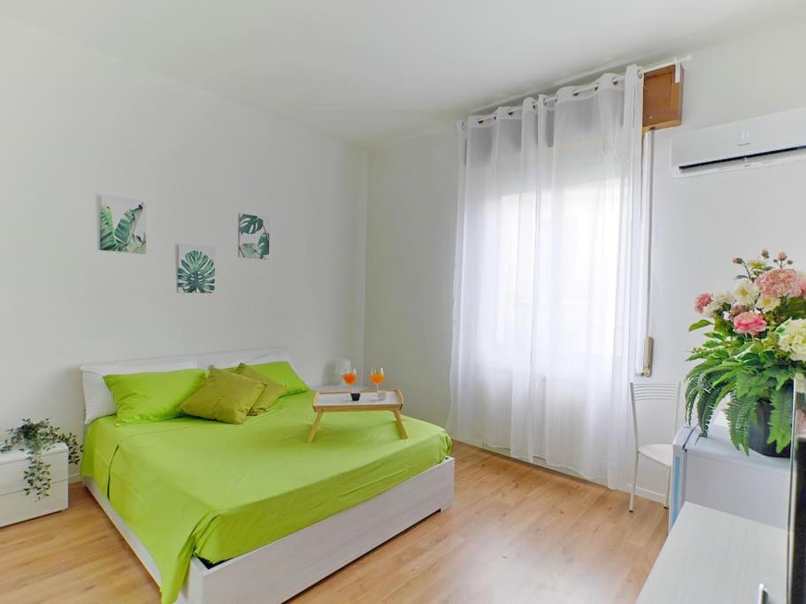ein Schlafzimmer mit einem grünen Bett in einem weißen Zimmer in der Unterkunft [RHO FIERA] Apartment near the Metro in Pero