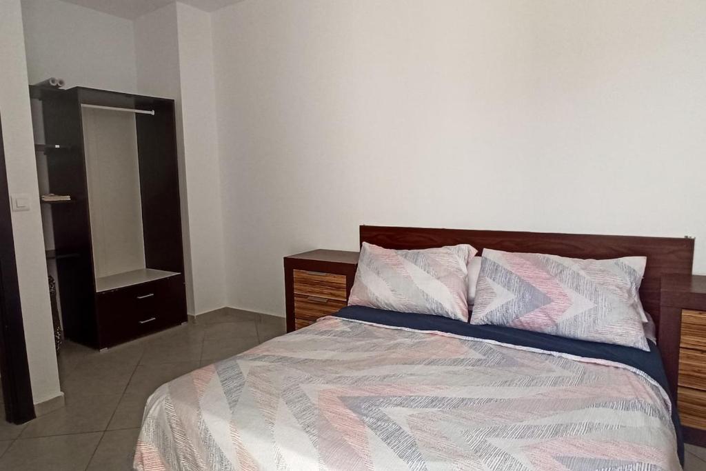 a bedroom with a bed with a dresser and a mirror at Séjour Paisible au Bord de la Nature. in Tangier
