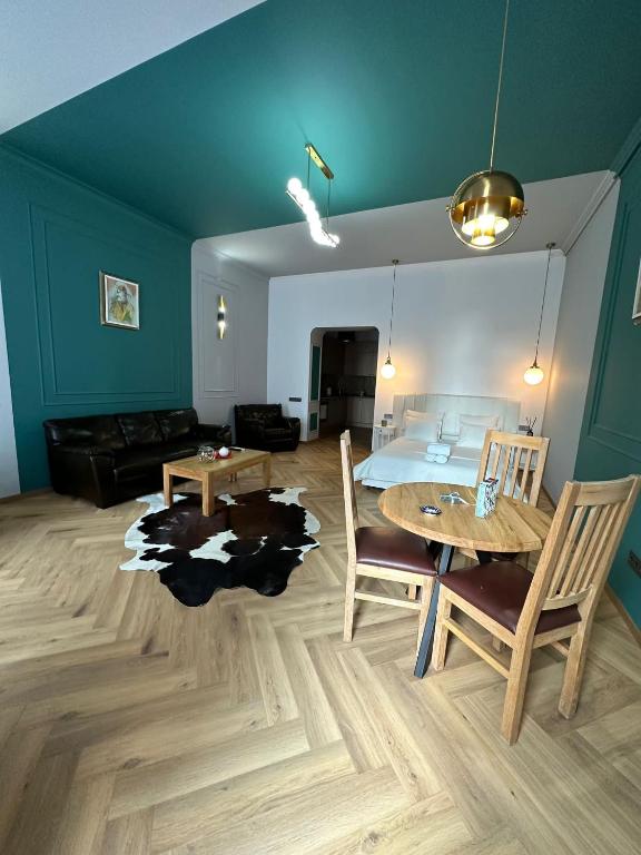 a living room with a table and a bed at Oyster Flat Victoriei in Bucharest