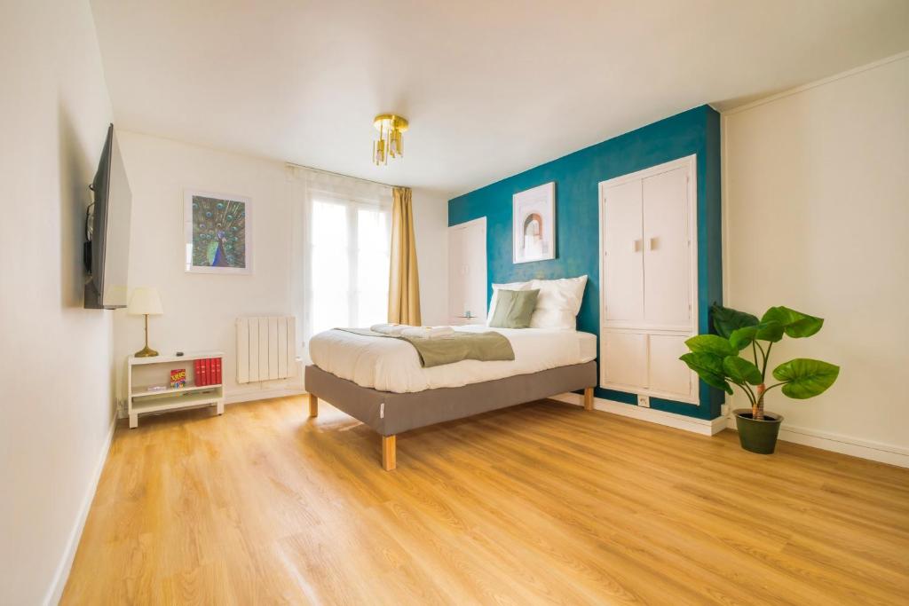 - une chambre avec un lit et un mur bleu dans l'établissement Sweet Champagne - Centre-ville, à Épernay