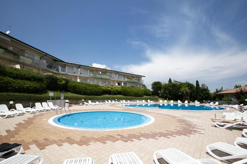 una gran piscina con tumbonas y un hotel en Casa Perla - Happy Rentals, en Desenzano del Garda