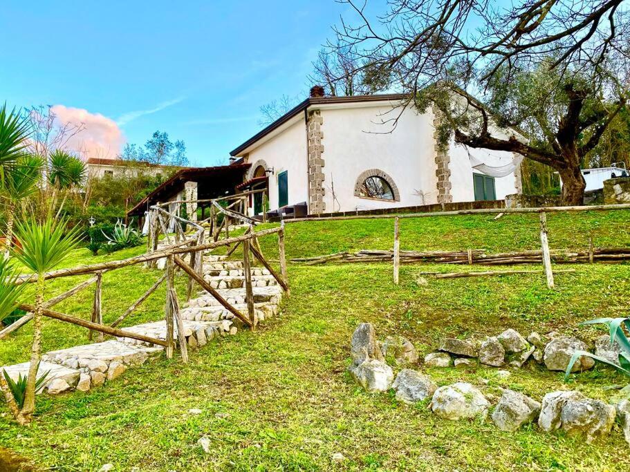 una casa en una colina con un patio con rocas en La Cascina Scalera per il tuo relax con piscina sauna ed Idromassaggio, en Castel Campagnano
