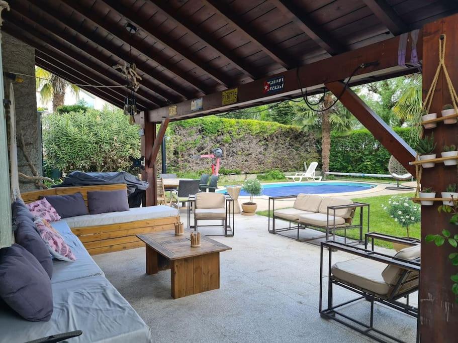 een patio met banken, een tafel en een zwembad bij Maison accessible à tous avec piscine! in La Tronche