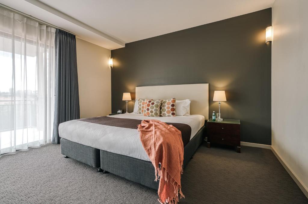 a bedroom with a bed and a large window at Il Mondo Boutique Hotel in Brisbane