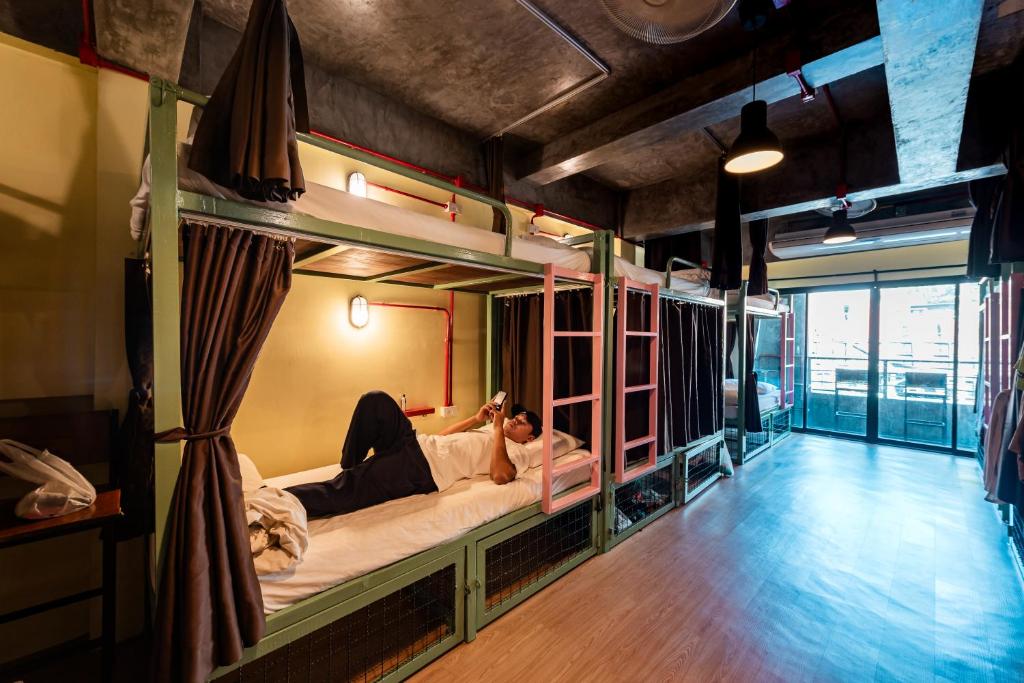 a person laying on a bunk bed in a room at Sleeper Hostel in Ao Nang Beach