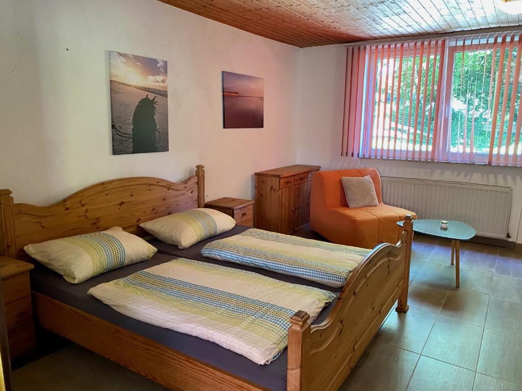 a bedroom with two beds and an orange chair at Gödelsteinhof in Contwig