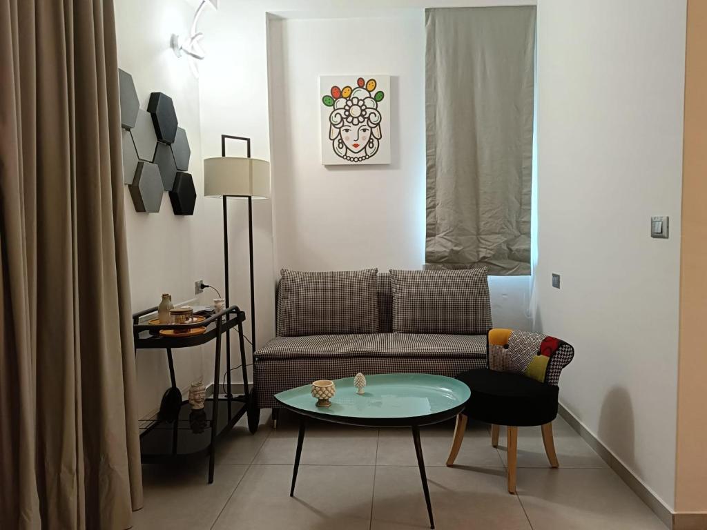 - un salon avec un canapé et une table dans l'établissement Sikelia Superior Rooms Milazzo, à Milazzo