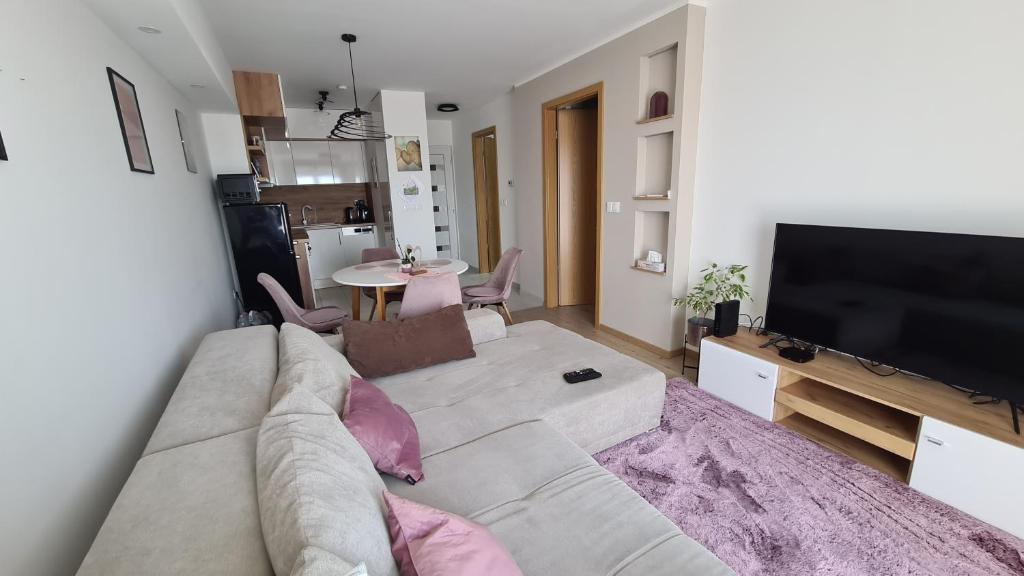 een woonkamer met een bank en een flatscreen-tv bij Riella Home in Szombathely