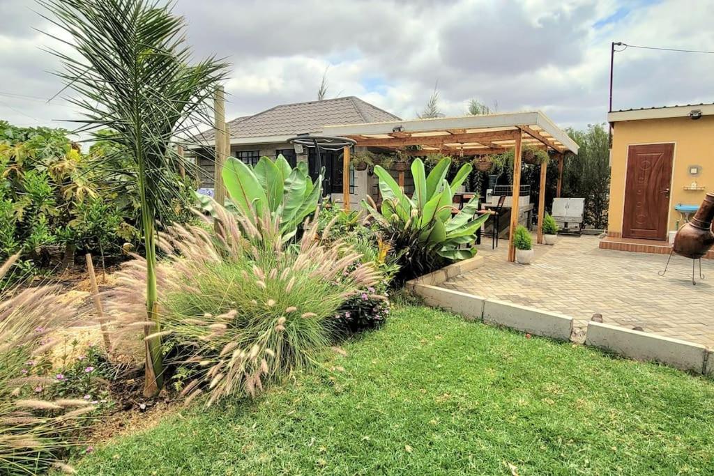 a house with a garden and a patio at The Cot in Kitengela 