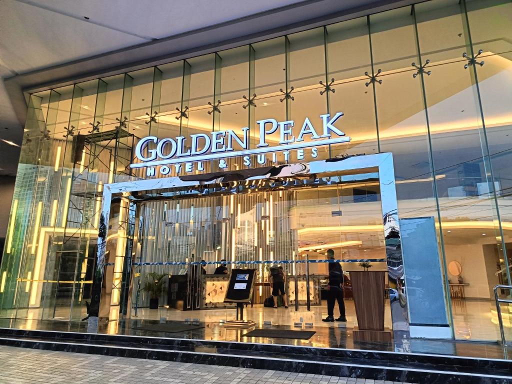 Golden Peak Hotel & Suites powered by Cocotel في مدينة سيبو: رجل يمشي أمام نافذة مخزن