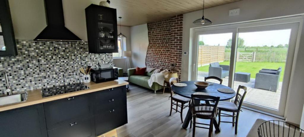eine Küche und ein Wohnzimmer mit einem Tisch und Stühlen in der Unterkunft le Repaire des Loups 