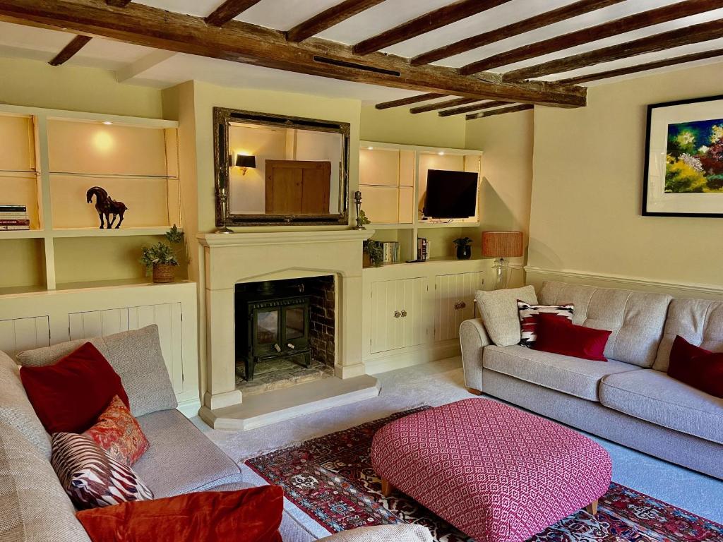 a living room with a couch and a fireplace at Bartley Mill Farmhouse in Wadhurst