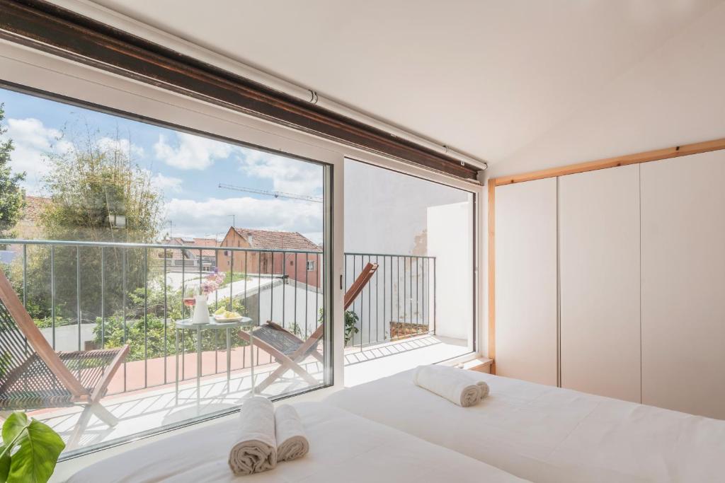 リスボンにあるApartamento com varanda, muito central, TTL333のベッドルーム1室(大きな窓、ベッド1台、バルコニー付)
