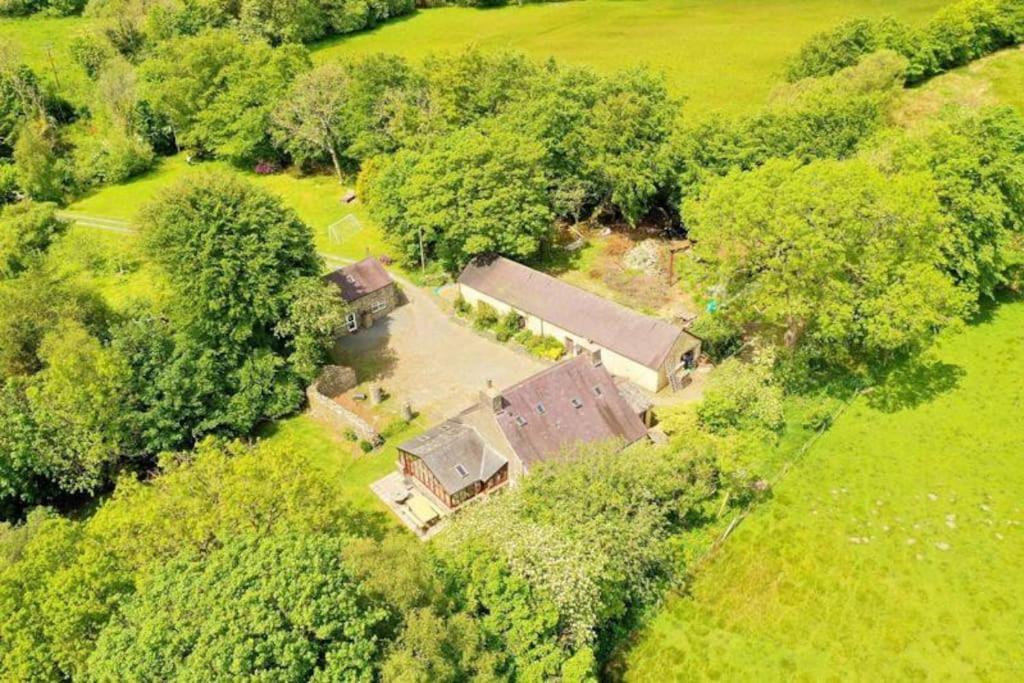 an overhead view of a house in a field with trees at Converted Granary on a rural small holding in Cross Inn