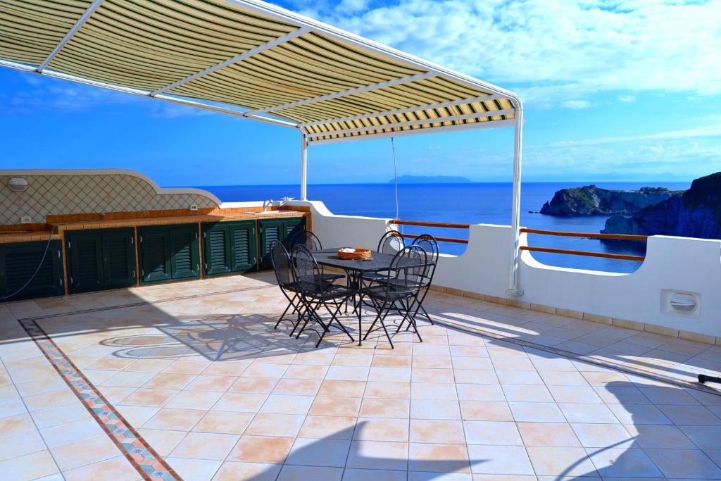 Un patio con sillas y una mesa en el balcón. en Maridea - La Terrazza en Ponza