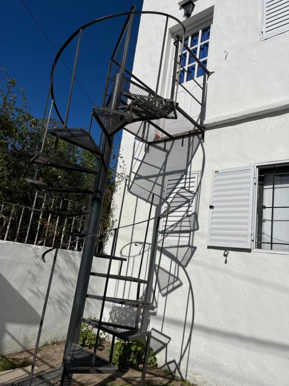 a metal spiral staircase next to a building at departamento mazzarello in Viedma