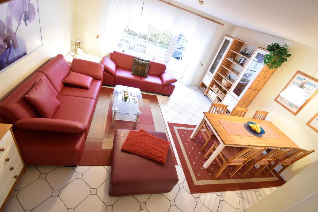 a living room with a red couch and a table at Haus Krabbe in Norddeich