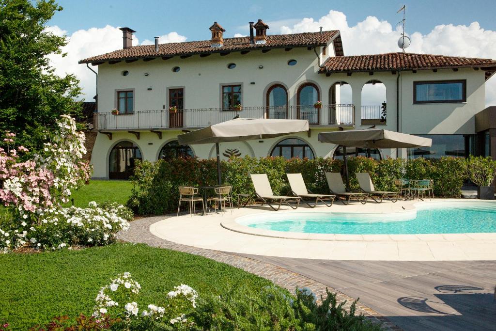 a house with a swimming pool in front of a house at Coltivare AgriRelais in La Morra