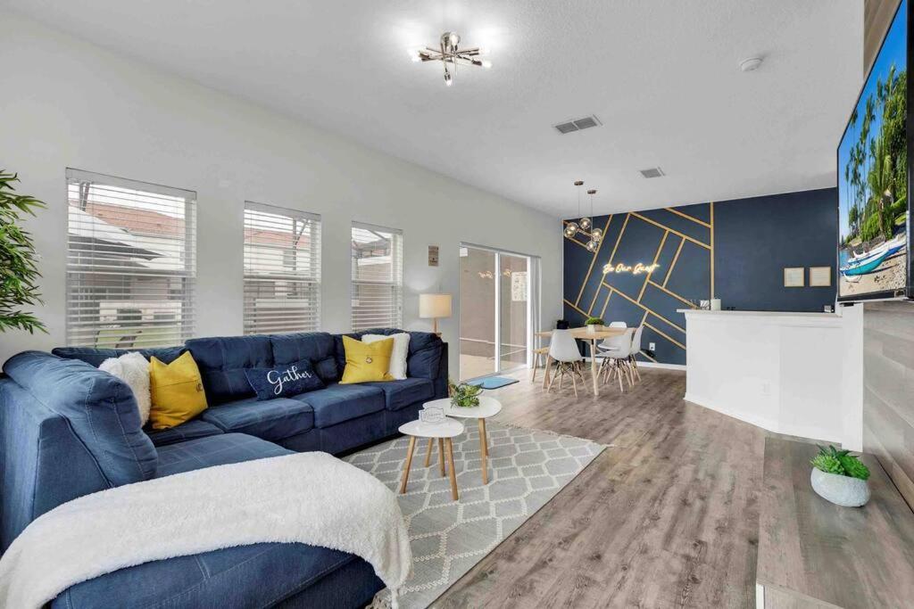 a living room with a blue couch and a table at Remarkable Cozy 4Bed-3Ba Townhouse in Kissimmee
