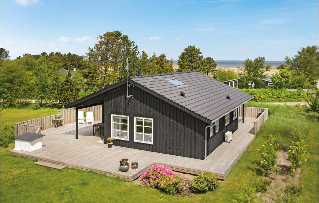 フレデリクスハウンにあるCozy Home In Frederikshavn With Kitchenのデッキ付きの黒い家の頭上の景色