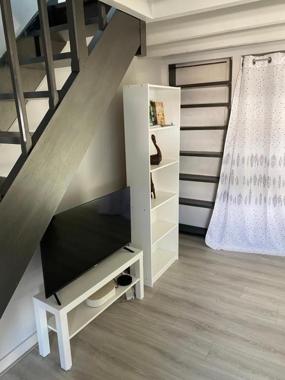 a living room with a tv and a staircase at Studio confortable centre-ville in Tours