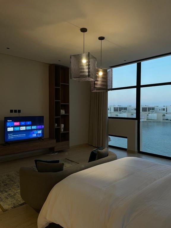 1 dormitorio con 1 cama grande y TV de pantalla plana en Elite Resort - Private Pool & Beach, en Bahía de la Media Luna