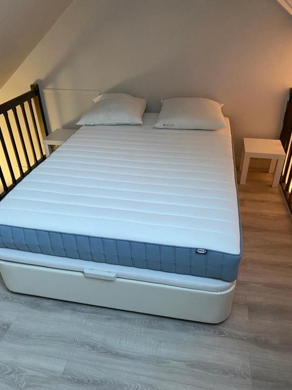 a bed in a room with a white mattress at Studio confortable centre-ville in Tours