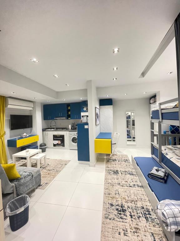 ein großes Wohnzimmer mit blauen Schränken und einer Couch in der Unterkunft Luxury Studio House 589-5 in Madinat as-Sadis min Uktubar