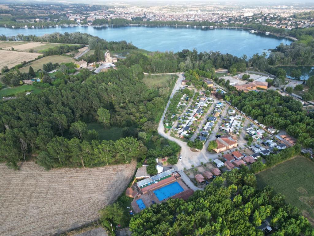 an aerial view of a parking lot next to a lake at Camping Bungalow el Llac de Banyoles in Porqueres