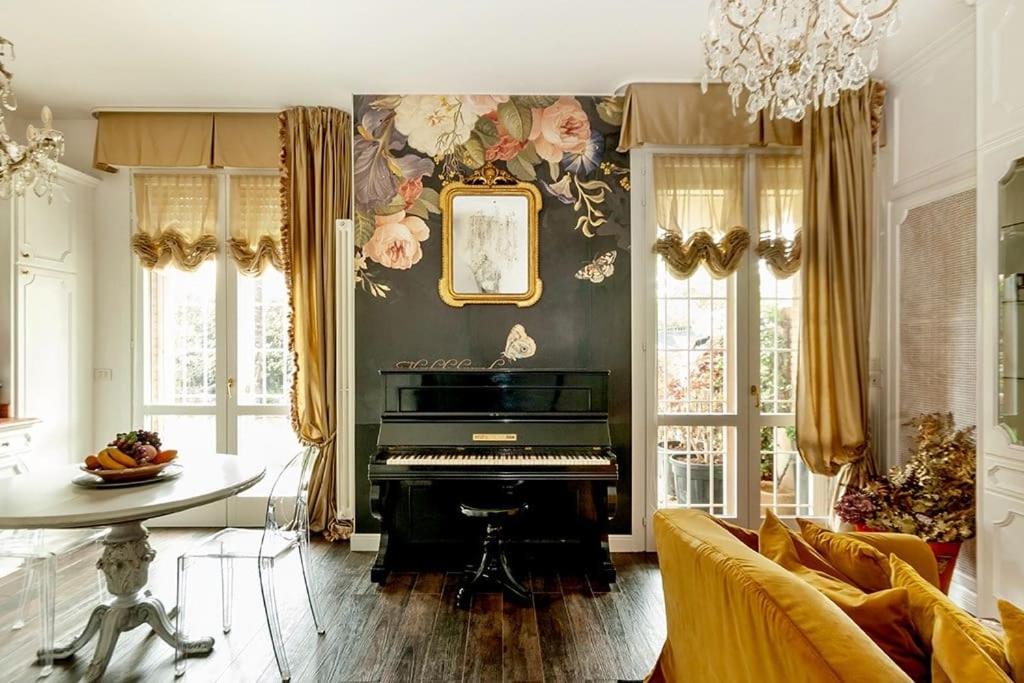 a living room with a piano and a table at Luxe Garden Apt for 2nr Bologna in Casalecchio di Reno