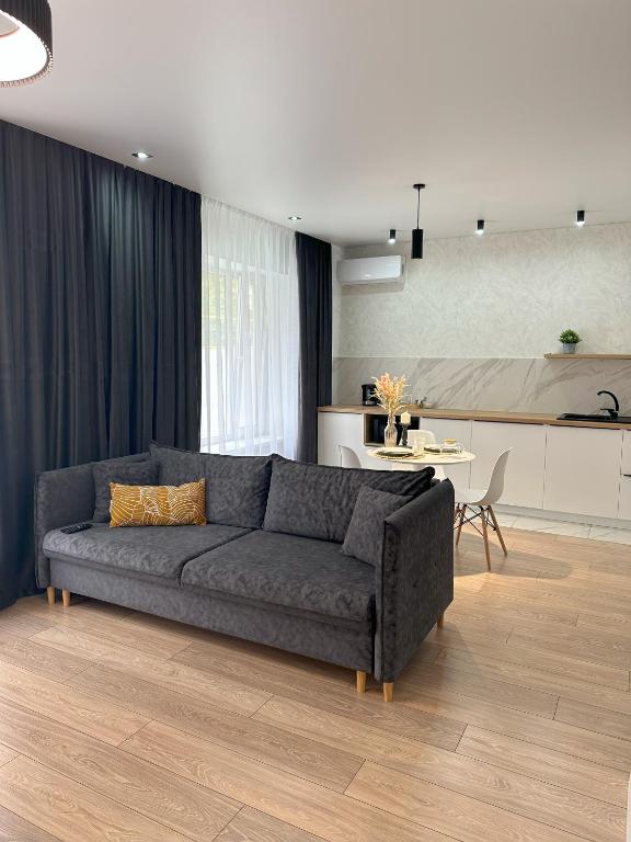 ein Wohnzimmer mit einem Sofa und einem Tisch in der Unterkunft Apart Inn - Апарт Отель in Oral