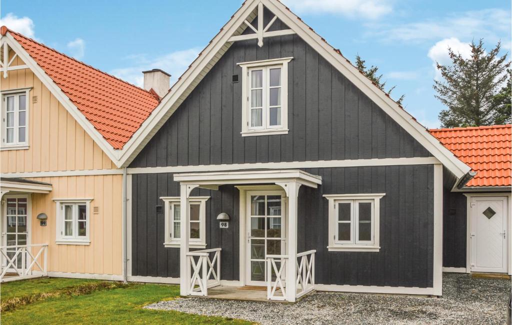una casa en blanco y negro con techo naranja en Blvandslyst, en Blåvand