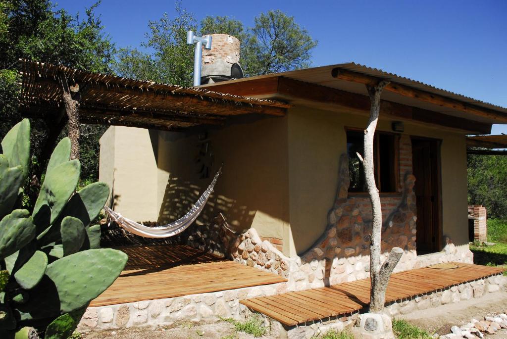 a house with a hammock in front of it at TrinidadTraslasierra in Las Rabonas