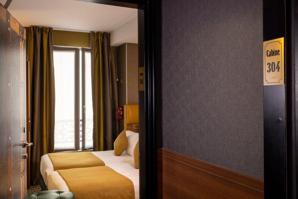 a hotel room with a bed and a window at Hotel Whistler - Gare du Nord in Paris