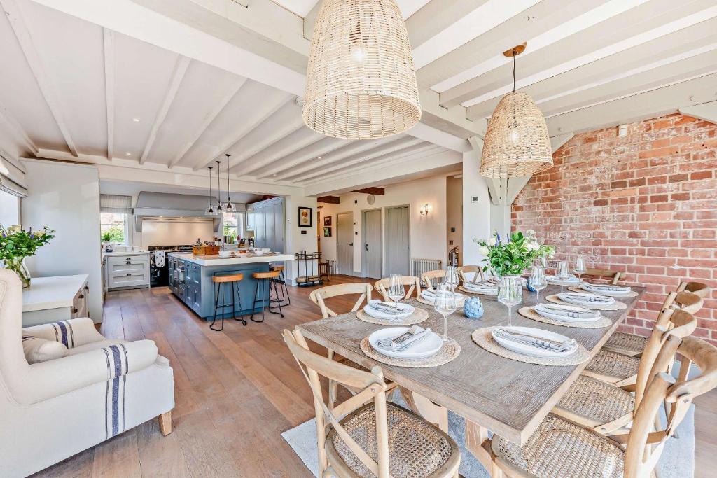 a dining room with a table and a brick wall at Bedgebury Oast by Bloom Stays in Goudhurst