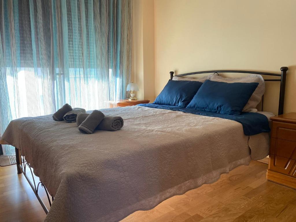 a bedroom with a large bed with blue pillows on it at Πανέμορφο διαμέρισμα δίπλα από το κέντρο! in Tríkala