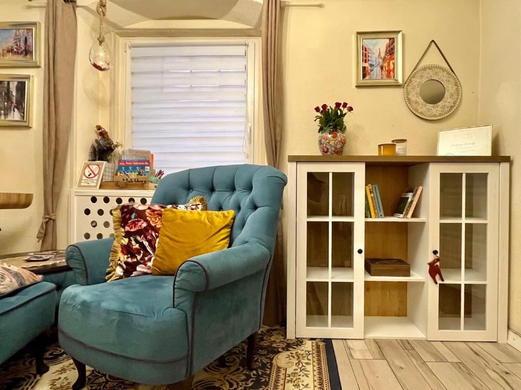 a blue chair with a yellow pillow in a living room at Apartament Majowa in Jelenia Góra