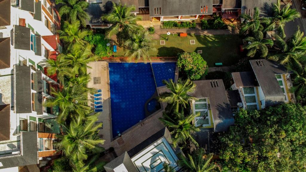 an overhead view of a swimming pool with palm trees at Goa Chillout Apartment - 1BHK, Baga in Baga