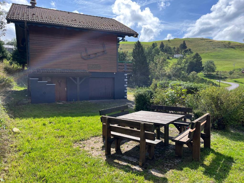 a picnic table and bench in front of a cabin at Chalet Les Sapins sauna au pied des pistes in La Bresse