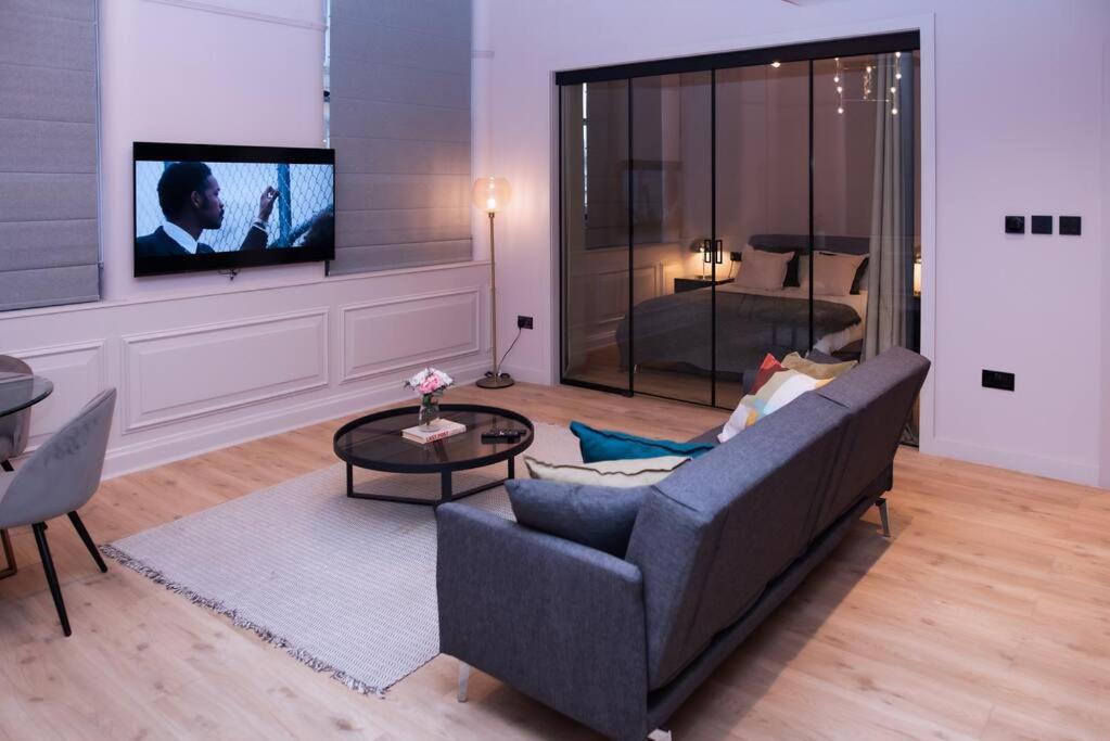 a living room with a couch and a tv at Luxurious stunning 2bedroom apartment in Manchester