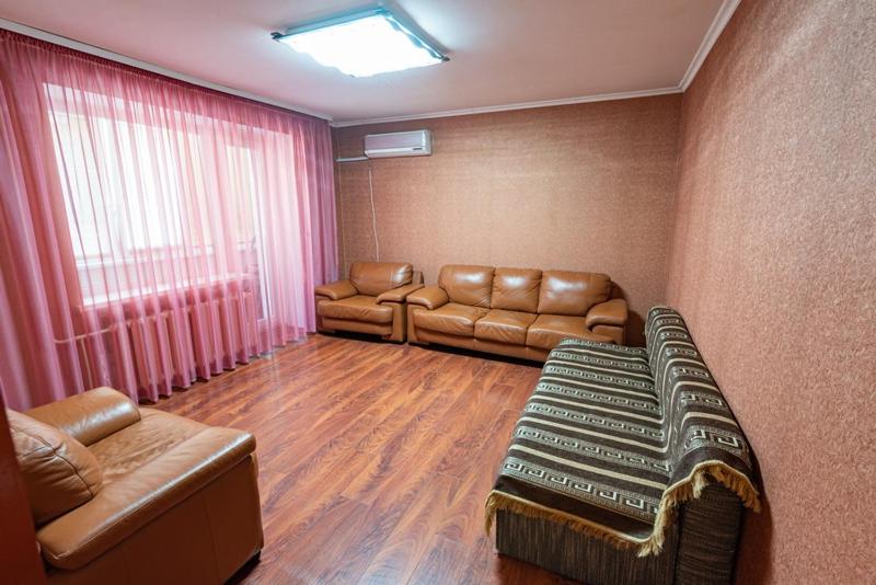 sala de estar con muebles de cuero y ventana en вулиця Митницька 55, en Cherkasy