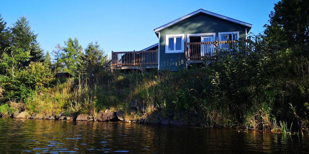 uma casa numa colina ao lado de um rio em Le Jasmin chalet complet Rivière Kayak Nature em Saint-Paulin
