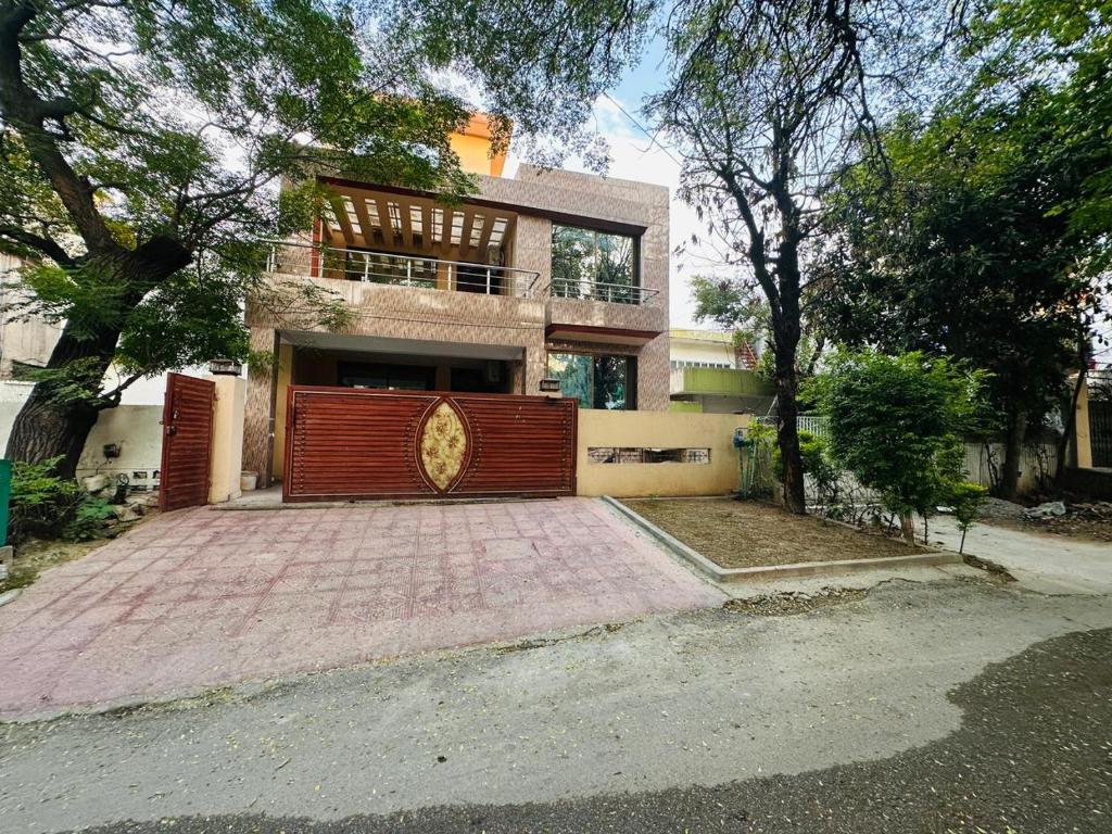 a large house with a red gate in front of it at Holidazzle Lodge Islamabad in Islamabad